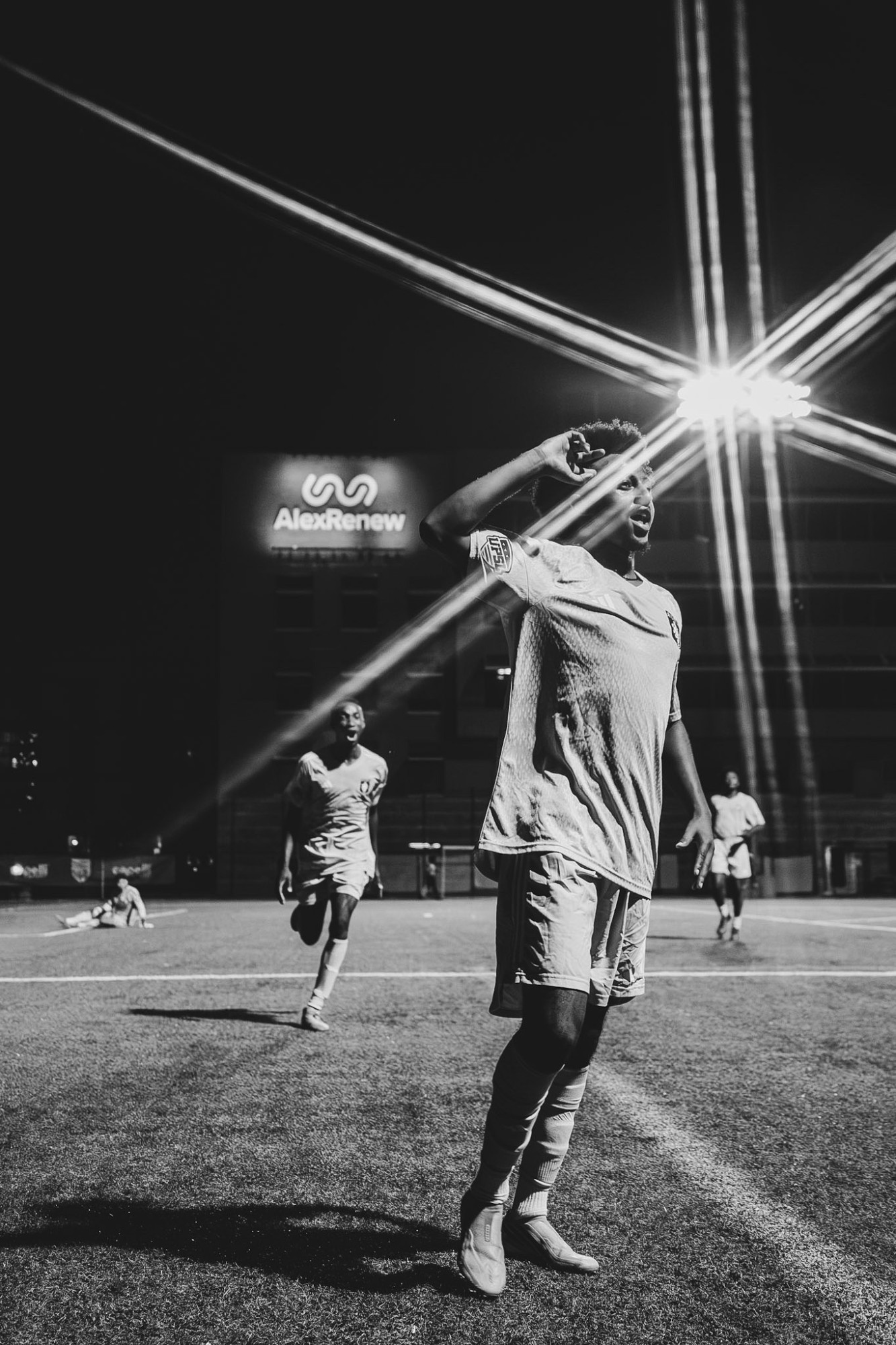 A player celebrating a goal under the floodlights