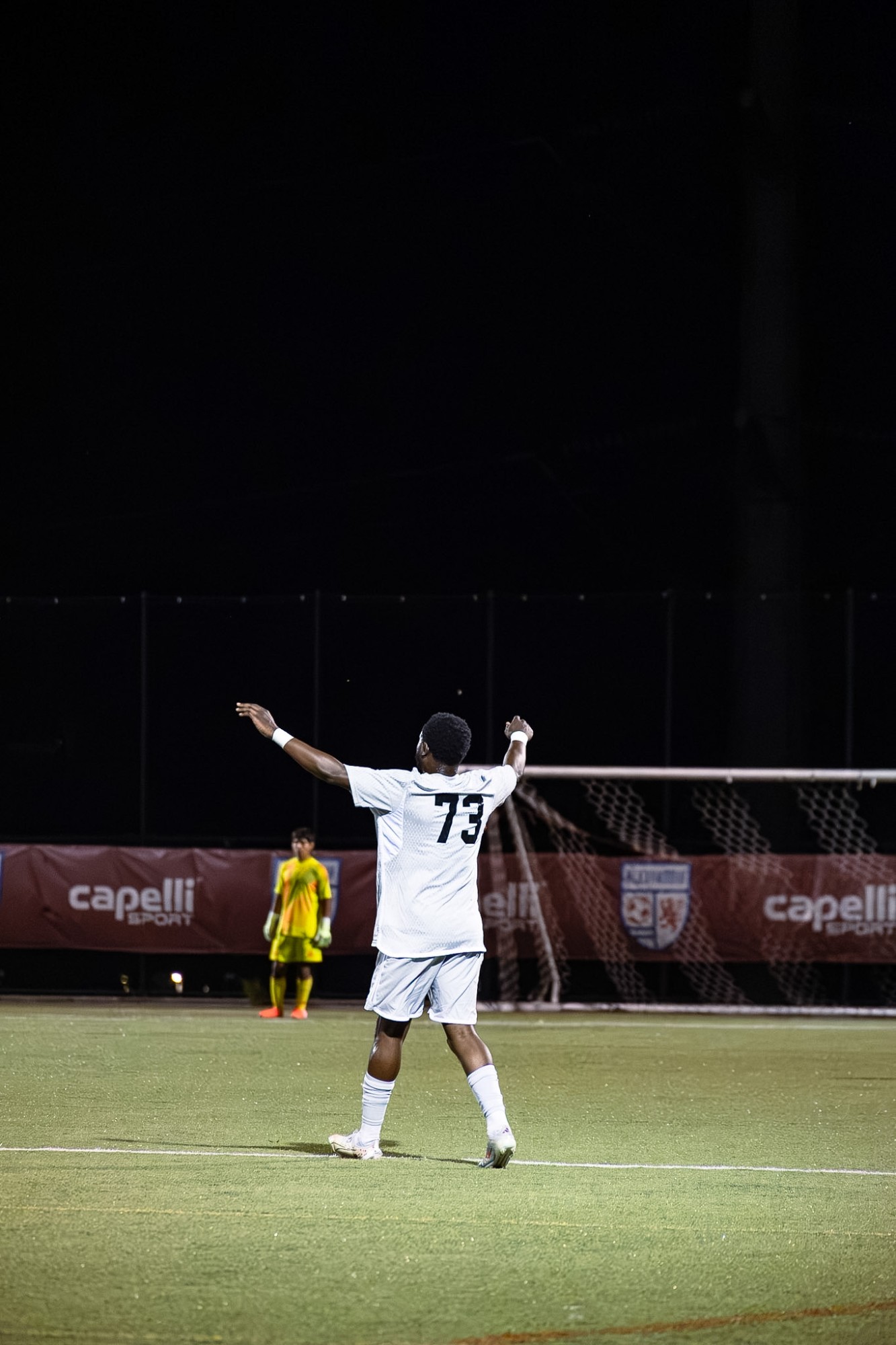 Number 73 celebrating with arms raised in front of the goal